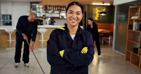 Girl, portrait and janitor with smile for maintenance job, hygiene and arms crossed with team in uniform