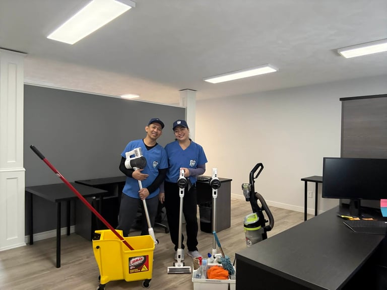 Two people in blue shirts using gym equipment and a yellow mop bucket in an indoor exercise room
